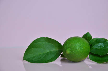 lime juice with lime leaves on pink table. Detox diet. top view. copy space. three limes.の写真素材