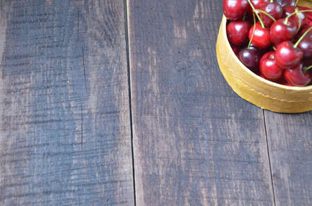 Fresh cherries in basket on wooden tableの写真素材