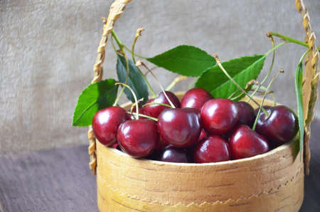 Cherry homemade russian pies on wooden background and cup of tea. with cherry in the basketの写真素材