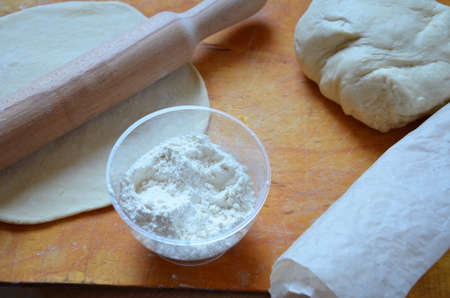 Home autumn, summer baking, puff pastries. Apple strudel with nuts, raisins, cinnamon and powdered sugar. On wooden table. Sliced, with ingredients. Copy space top view. pie ingredientsの写真素材
