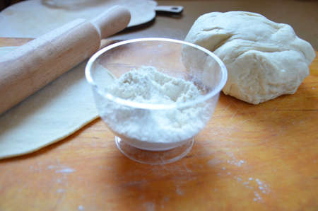 Home autumn, summer baking, puff pastries. Apple strudel with nuts, raisins, cinnamon and powdered sugar. On wooden table. Sliced, with ingredients. Copy space top view. pie ingredientsの写真素材