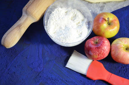 Various ingredients for winter seasonal baking and other recipes, honey, apples, herbs and spices on a dark blue background. Top view.の写真素材