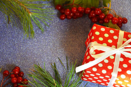 Christmas composition. Christmas gift, pine cones, fir branches on on a shimmering blue background, boke background. Flat lay, top view, copy spaceの写真素材