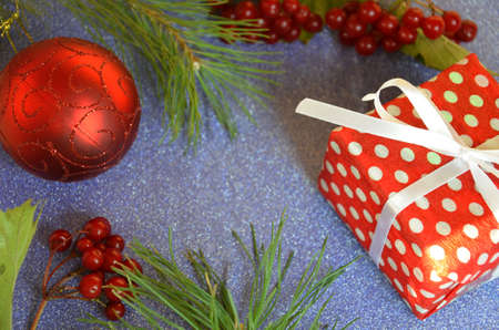 Christmas composition. Christmas gift, pine cones, fir branches on on a shimmering blue background, boke background. Flat lay, top view, copy spaceの写真素材