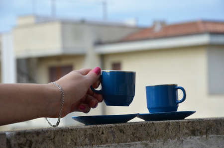 Two blue cups of coffee with panoramic view of a city in background. on the balcony against the backdrop of the old European city. good morning, romanceの写真素材