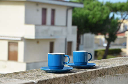 Two blue cups of coffee with panoramic view of a city in background. on the balcony against the backdrop of the old European city. good morning, romance.の写真素材