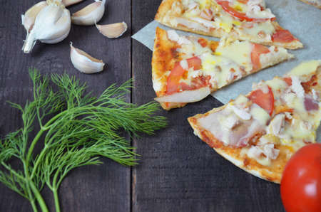 Pizza salami cheese ham. Hot Homemade Pepperoni Pizza Ready to Eat . with ingredients for cooking, greens, garlic, tomato. cheese and olive oilの写真素材