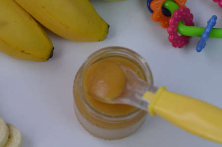 Baby food, banana mashed puree and bananas on a white backgroundの写真素材