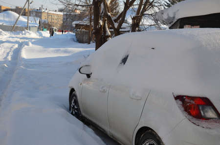 A car under the snow after snowfallの写真素材
