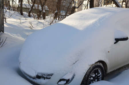 A car under the snow after snowfallの写真素材