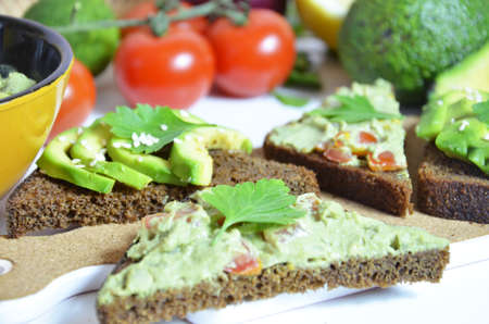 Guacamole and bread. Toast with avocado on white background. Homemade Mexican healthy vegan foodの写真素材