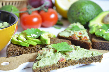 Guacamole and bread. Toast with avocado on white background. Homemade Mexican healthy vegan foodの写真素材