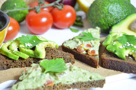 Guacamole and bread. Toast with avocado on white background. Homemade Mexican healthy vegan foodの写真素材