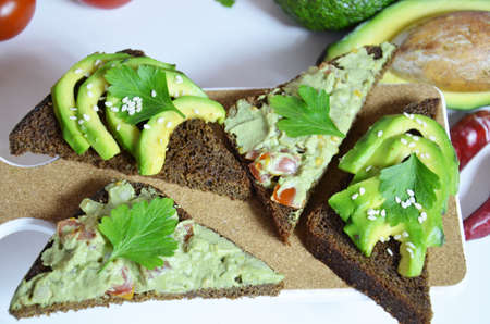 Guacamole and bread. Toast with avocado on white background. Homemade Mexican healthy vegan foodの写真素材