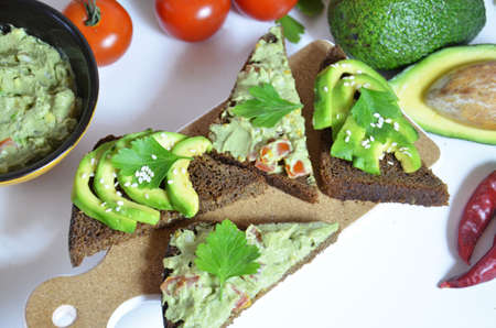 Guacamole and bread. Toast with avocado on white background. Homemade Mexican healthy vegan foodの写真素材