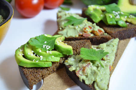 Guacamole and bread. Toast with avocado on white background. Homemade Mexican healthy vegan foodの写真素材