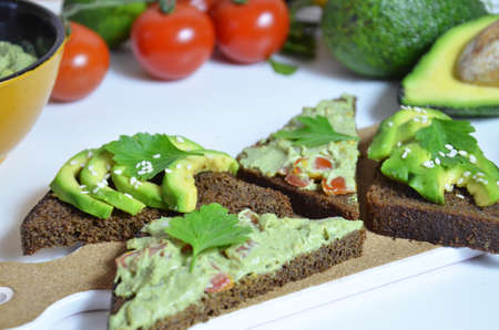 Guacamole and bread. Toast with avocado on white background. Homemade Mexican healthy vegan foodの写真素材