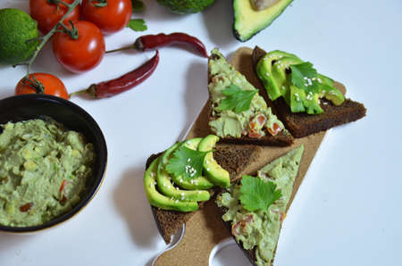 Guacamole and bread. Toast with avocado on white background. Homemade Mexican healthy vegan foodの写真素材