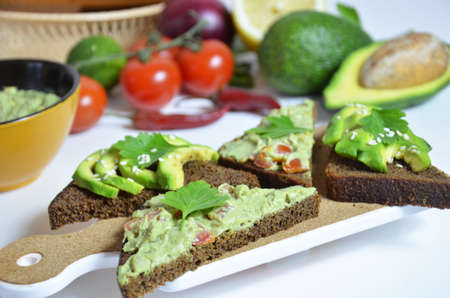 Guacamole and bread. Toast with avocado on white background. Homemade Mexican healthy vegan foodの写真素材