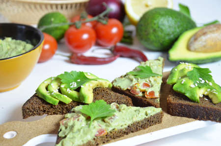 Guacamole and bread. Toast with avocado on white background. Homemade Mexican healthy vegan foodの写真素材