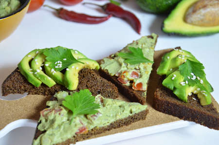 Guacamole and bread. Toast with avocado on white background. Homemade Mexican healthy vegan foodの写真素材