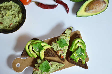 Guacamole and bread. Toast with avocado on white background. Homemade Mexican healthy vegan foodの写真素材