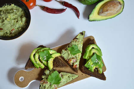 Guacamole and bread. Toast with avocado on white background. Homemade Mexican healthy vegan foodの写真素材