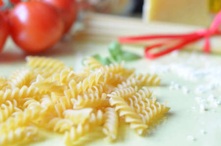 composition of healthy food ingredients on yellow white background, top view. Ingredients for making macron, spaghetti, pasta. Tomatoes, basil, parmesan cheese, graterの写真素材