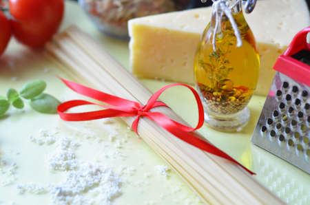 composition of healthy food ingredients on yellow white background, top view. Ingredients for making macron, spaghetti, pasta. Tomatoes, basil, parmesan cheese, graterの写真素材