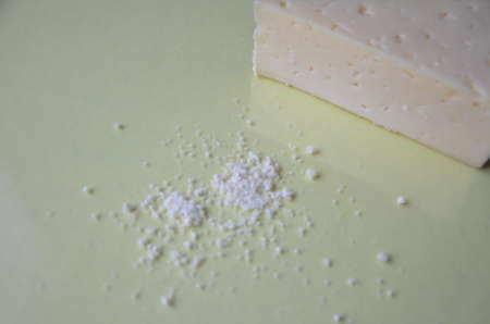 grated parmesan cheese and metal grater on grated parmesan cheese and metal grater on yellow background. Ingredients for cooking traditional Italian dishes. Spaghetti, pasta, pizza. Italian hard parmesan cheese, fresh green basil.の写真素材