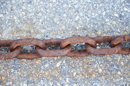 Rusty metal chains on the background of stones.の写真素材