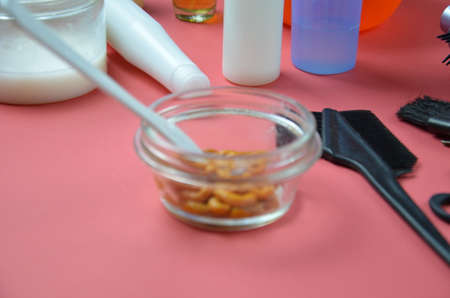 Barber shop set with hair dye, hairbrush, scissors, spray and brush on pink red background.の写真素材