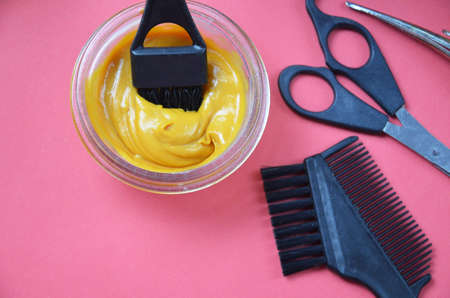 Barber shop set with hair dye, hairbrush, scissors, spray and brush on pink red background.の写真素材