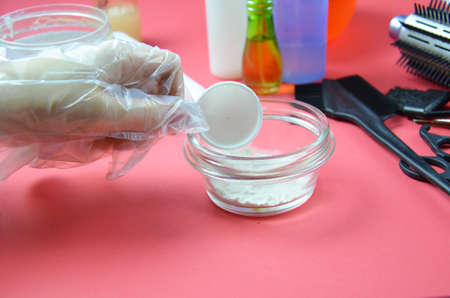 Barber shop set with hair dye, hairbrush, scissors, spray and brush on pink red background.の写真素材
