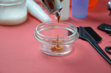 Barber shop set with hair dye, hairbrush, scissors, spray and brush on pink red background.の写真素材