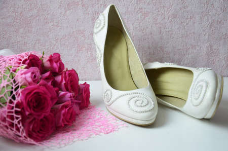 wedding shoes and wedding bouquet of white rosesの写真素材