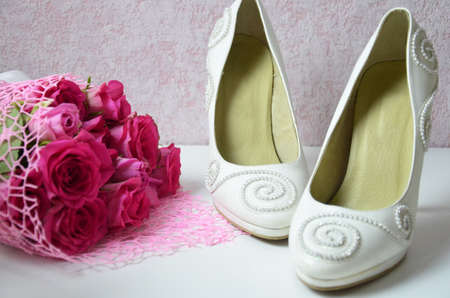 wedding shoes and wedding bouquet of white rosesの写真素材