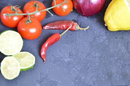 Set of traditional mexican dishes - burrito bowl, nachos, guacamole and salsa dressing, chili peppers, chopped jalapeño and lime on red background. Overhead view, flat lay, copy spaceの写真素材