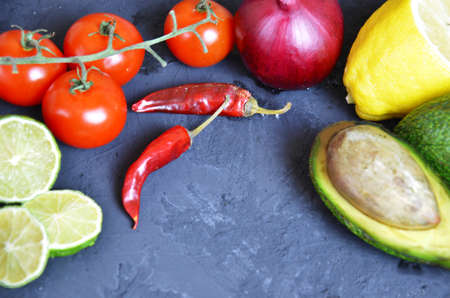 Set of traditional mexican dishes - burrito bowl, nachos, guacamole and salsa dressing, chili peppers, chopped jalapeño and lime on red background. Overhead view, flat lay, copy spaceの写真素材
