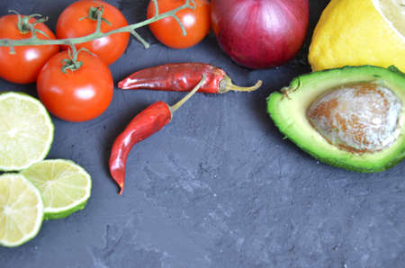 Set of traditional mexican dishes - burrito bowl, nachos, guacamole and salsa dressing, chili peppers, chopped jalapeño and lime on red background. Overhead view, flat lay, copy spaceの写真素材