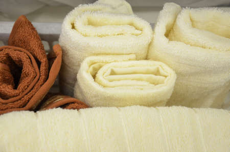 spa towels differnt brown and white colors in the basket roll upの写真素材