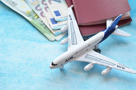 Preparation for Traveling concept, watch, airplane, money, passport, map, phone on sky blue background with copy space. online ticket booking conceptの写真素材