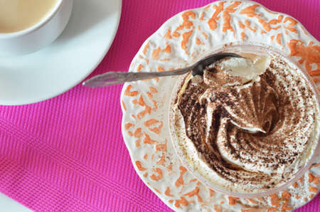 coffee with whipped cream and chocolate for breakfast. gourmet breakfast, coffee with milk, milk jug, tasty cake with whipped cream, sprinkled with chocolate or cinnamon on a raspberry backgroundの写真素材