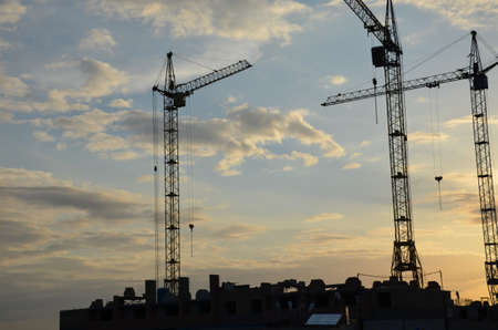 Construction crane near the building under construction. Close up of a construction crane. Self-erection crane. Construction siteの写真素材