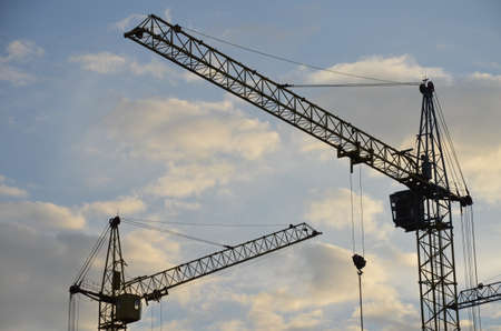 Construction crane near the building under construction. Close up of a construction crane. Self-erection crane. Construction siteの写真素材