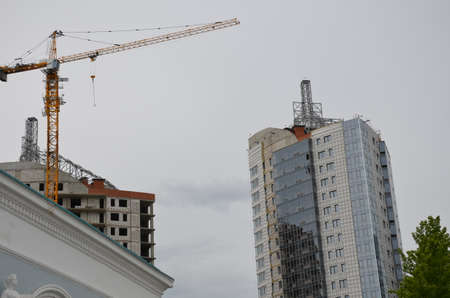 Crane and building construction site against blue skyの写真素材