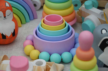 wooden toys for newborns. pyramid cups, balls, beads. Top view on multicolor toy bricks on white wooden background. Children toys on the tableの写真素材