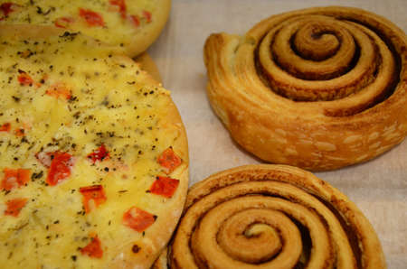 Fresh baked cinnamon rolls on steel baking tray. Homemade cinnamon buns for breakfast. Swedish sweet pastry background in a bakery shop.の写真素材