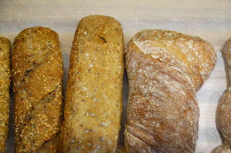 Different kinds of bread rolls on on baking paper from above. Kitchen or bakery poster design.の写真素材