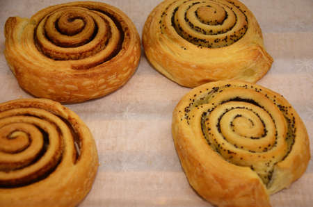 Fresh baked cinnamon rolls on steel baking tray. Homemade cinnamon buns for breakfast. Swedish sweet pastry background in a bakery shop.の写真素材